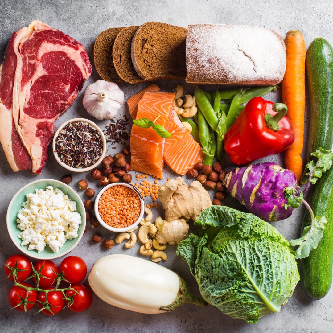Assortment of healthy balanced food composition: meat, fish, vegetables, bread, cereals, beans, stone background. Raw ingredients for cooking healthy meal, good for diet, clean eating concept